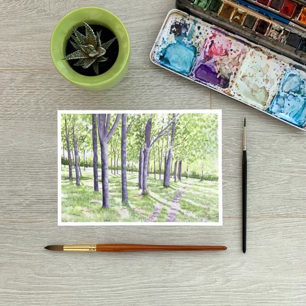 A5 print of a woodland watercolour painting - sunlight through the trees - by Clare Willcocks